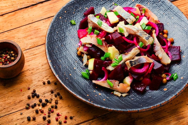 Salade met gezouten haring, bieten, uien en doperwtjes.