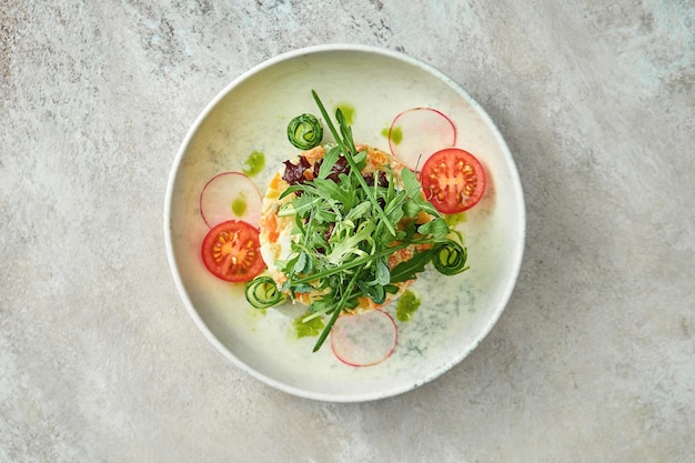 Salade met groenten en zalm in een bord op een gestructureerde achtergrond. Close-up, selectieve focus