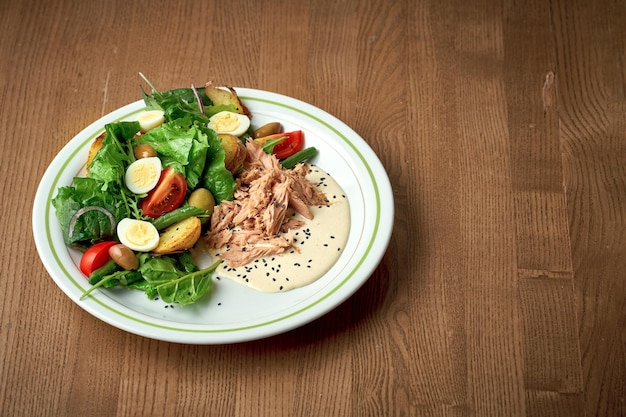Salade met groenten tonijn en gekookt ei Salade Nicoise Houten achtergrond