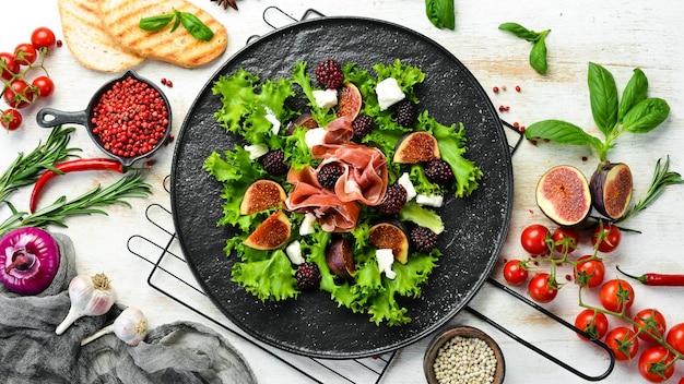 Salade met ham, bramen, vijgen en fetakaas Op een zwarte stenen plaat Gezonde voeding Bovenaanzicht
