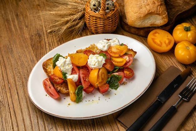 salade met kaastomaten op croutons op een houten tafel