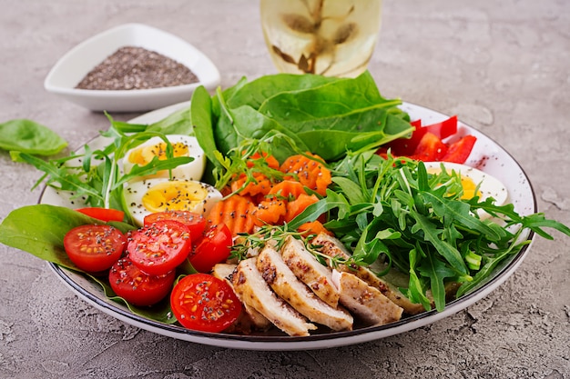 Salade met kerstomaatjes, kipfilet, eieren, wortel, rucola en spinazie