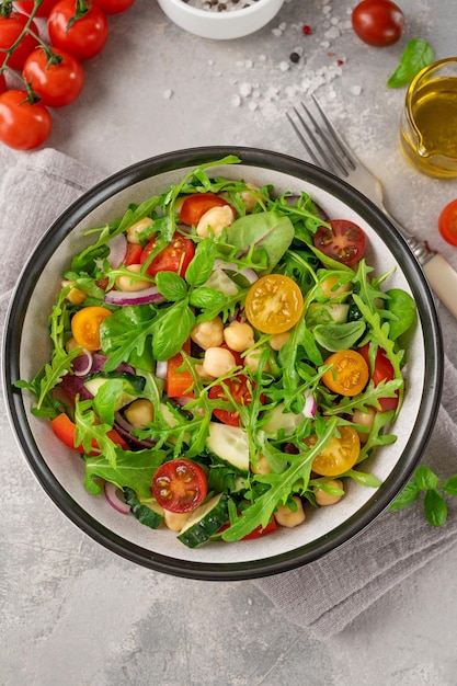 Salade met kikkererwten, groene bladeren en verse groenten in een kom Gezonde voeding Bovenaanzicht kopieerruimte