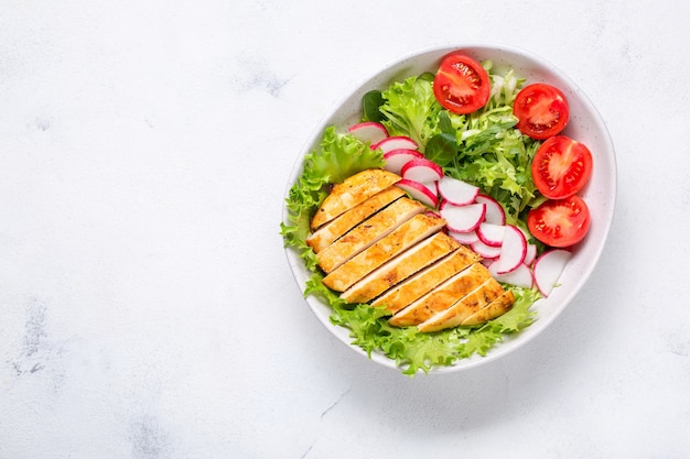 Salade Met Kipfilet. Keto-dieet, gezonde voeding, dieetlunch. Bovenaanzicht op witte achtergrond.