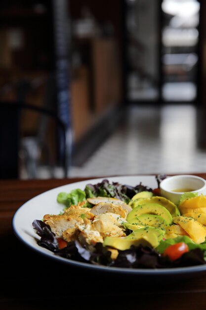 Salade met Kippenavocado en mango op houten ondergrond