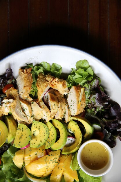 Salade met Kippenavocado en mango op houten ondergrond