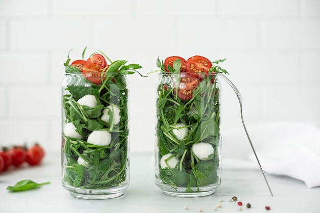 Foto salade met mozzarella rucola cherrytomaatjes in een glazen pot