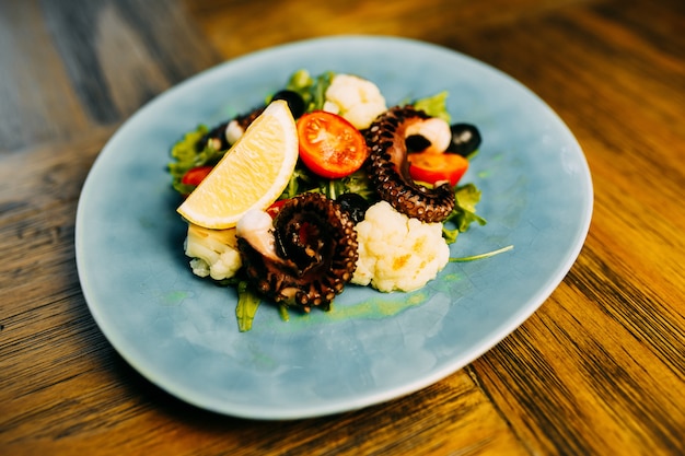 Salade met octopus en bloemkool op de plaat.