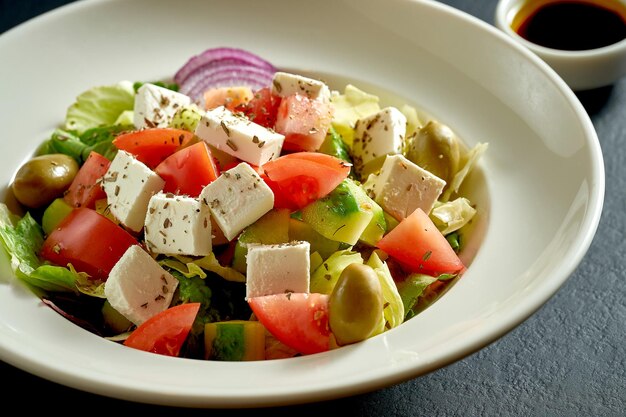 Salade met olijven, tomaten en feta in een witte plaat. Griekse salade