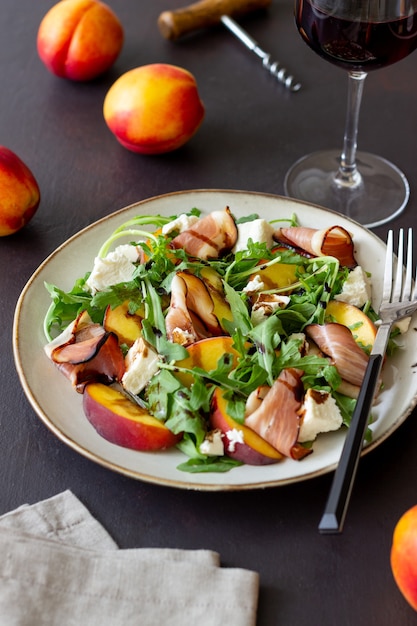 Salade met perziken, rucola, kaas en jamon. Gezond eten.