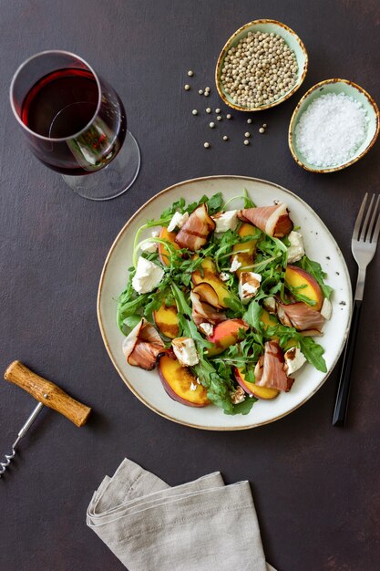 Salade met perziken, rucola, kaas en jamon. Gezond eten.