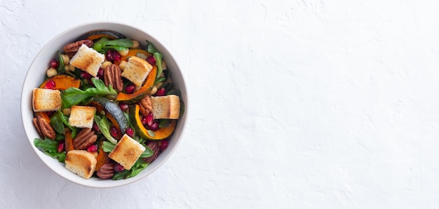 Salade met pompoen, granaatappel, pecannoten en croutons. Gezond eten. Vegetarisch eten.