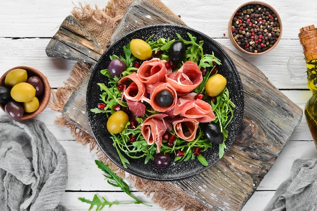 Salade met Prosciutto olijven en rucola Koude snacks Bovenaanzicht Vrije ruimte voor uw tekst