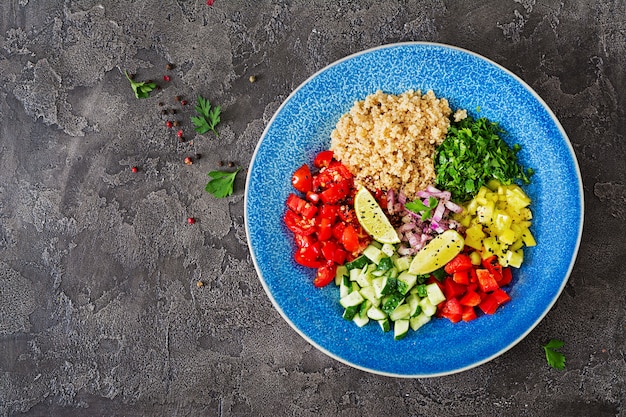 Salade met quinoa, rucola, paprika, tomaten en komkommer in kom