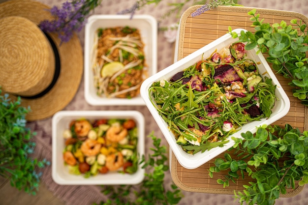 Salade met rucola, rode biet en fetakaas. vegetarisch eten. garnalensalade en Aziatische pad thai. samenstelling met natuurlijk decor. concept voedselbezorging