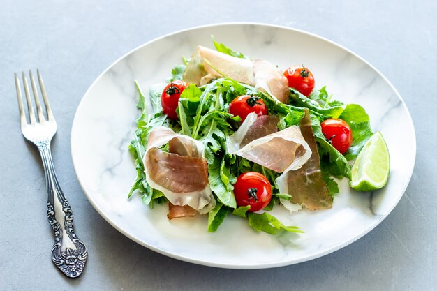 Salade met rucola, tomaten en prosciutto.