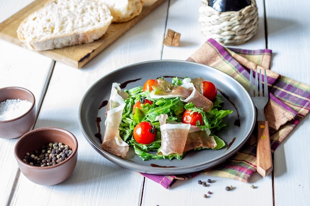 Salade met rucola, tomaten en prosciutto.