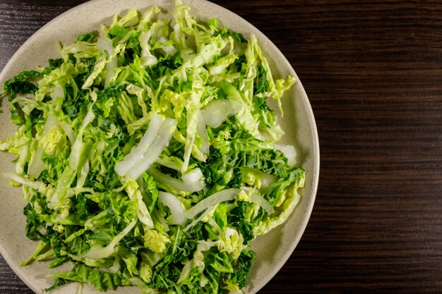 Salade met savooiekool en ui op houten tafel