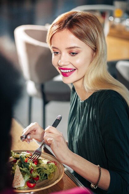 Salade met sla mooie blondharige vrouw die salade met sla en tomaat eet