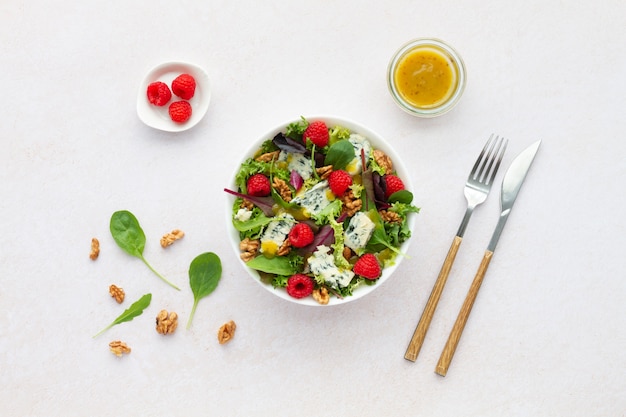 Foto salade met sla roquefort kaas frambozen walnoten en vinaigrette op witte achtergrond