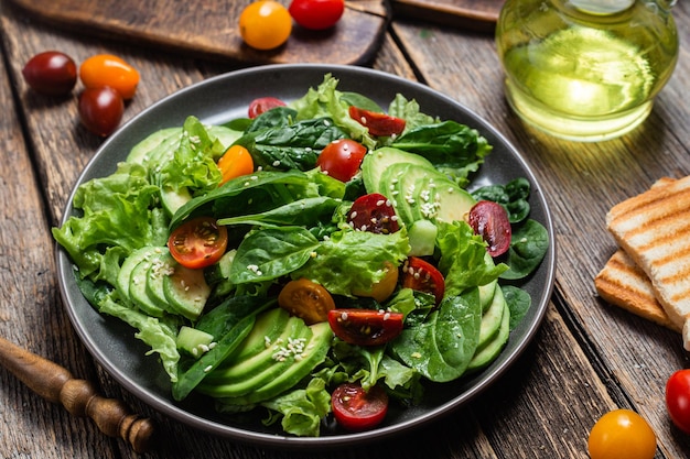 Salade met spinazie-avocado-tomaten in een bord Vegetarische salade