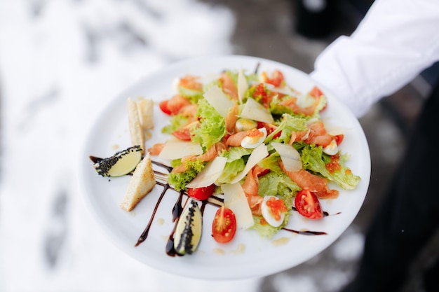 Salade met tomaten, eieren, zalm en kaviaar Heerlijke salade in het restaurant Foto op een licht wazige achtergrond