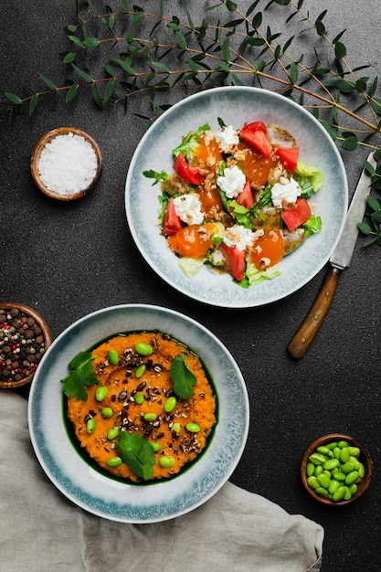 Salade met verse groenten en stracciatella en salade met verse groene erwt of sperziebonen Salade bovenaanzicht in betonnen tafel met kopieerruimte