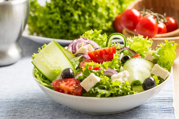 Salade met verse groenten olijven tomaten rode ui Griekse kaas feta en olijfolie.