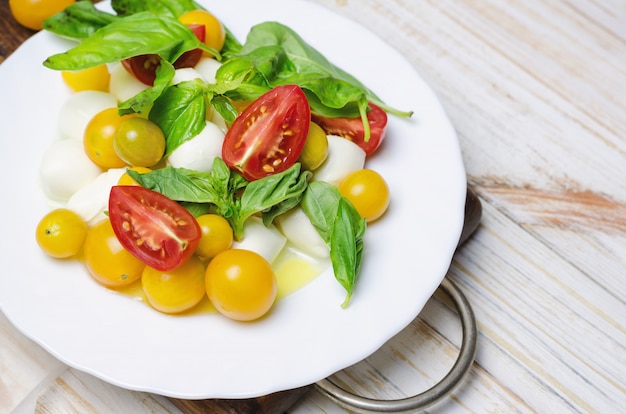 Salade met verse mozzarella, tomaten en basilicum.