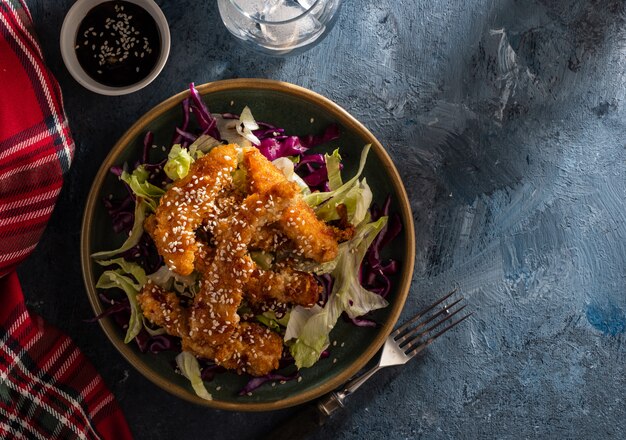 Salade met warme geglazuurde kip, bestrooid met sesamzaadjes. Chinese keuken. Aziatische cultuur