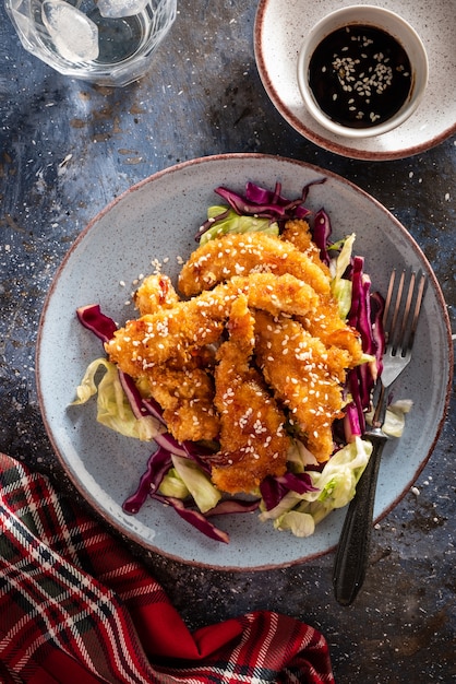 Salade met warme geglazuurde kip, bestrooid met sesamzaadjes. Chinese keuken. Aziatische cultuur