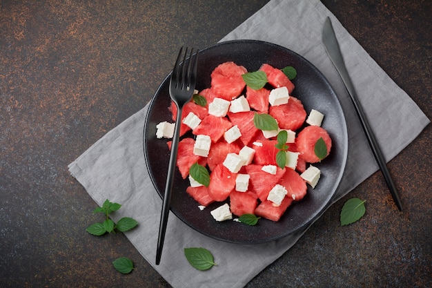 Salade met watermeloen en fetakaas op een zwarte plaat