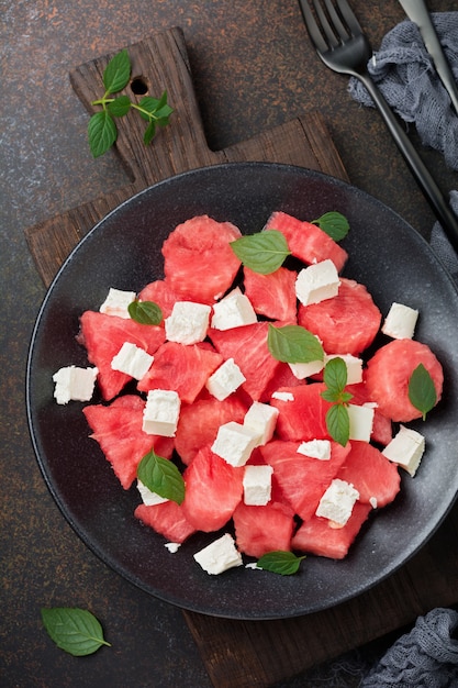 Salade met watermeloen en fetakaas op een zwarte plaat