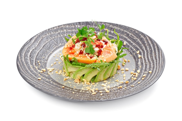 Salade met zalm en avocado op wit wordt geïsoleerd