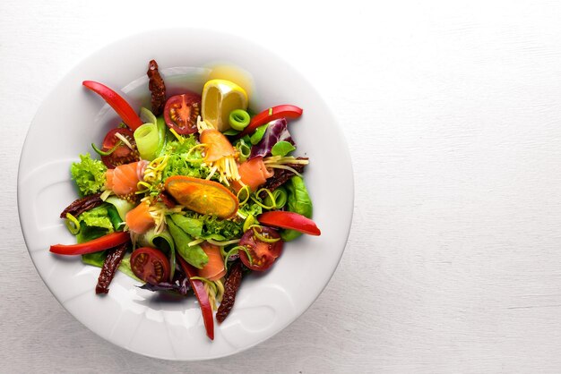 Salade met zalm en verse groenten en kruiden Italiaanse keuken Bovenaanzicht op houten achtergrond