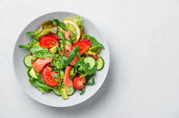 Salade met zalm en verse groenten op een lichtgrijze achtergrond Vitaminerijke omega 3 salade Bovenaanzicht kopieerruimte