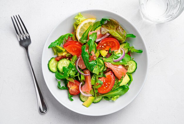 Salade met zalmgroenten, kruiden en lijnzaad en sesamzaad op een lichtgrijze achtergrond Gezonde voedingssalade Bovenaanzicht kopieerruimte