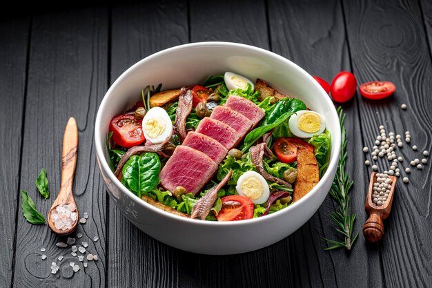 Foto salade nisuaz met tonijn ansjovis aardappelen kersen tomaten salade mix olijfolie en kwartel ei franse keuken