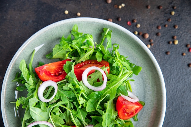 Salade rucola tomaat ui verse groente plaat maaltijd snack op tafel kopieer ruimte voedsel