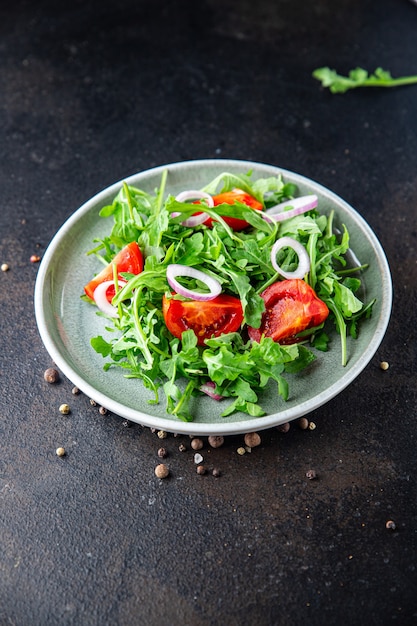 Salade rucola tomaat ui verse groente plaat maaltijd snack op tafel kopieer ruimte voedsel