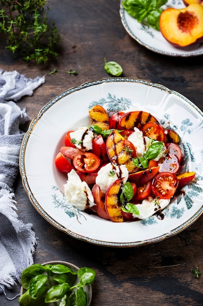 Salade van gegrilde perzik Caprese met mozzarella en tomaten