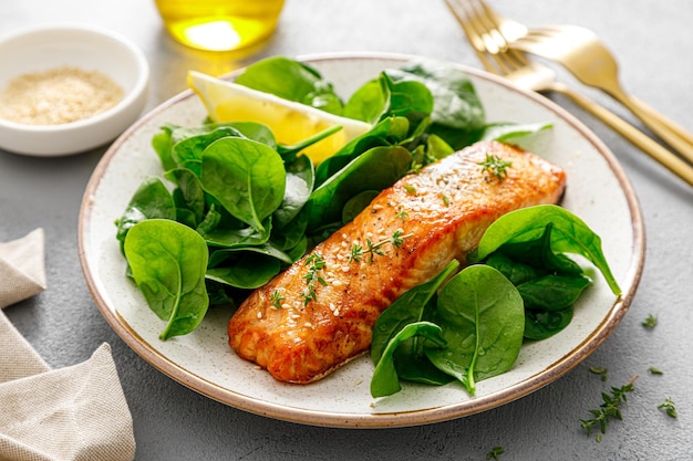 Salade van gegrilde zalm en verse spinazie gekleed met citroen