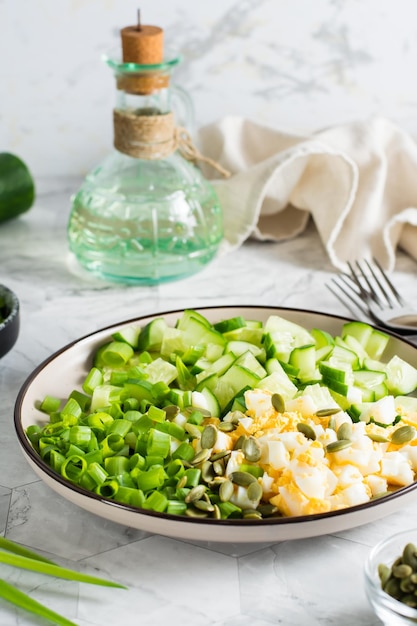 Salade van komkommer gekookt ei en groene ui op een bord Ketogeen dieet Verticale weergave Close-up