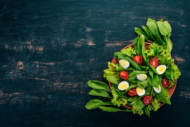 Salade van spinazie en kwarteleitjes op een houten ondergrond Gezonde voeding Bovenaanzicht Kopieer de ruimte