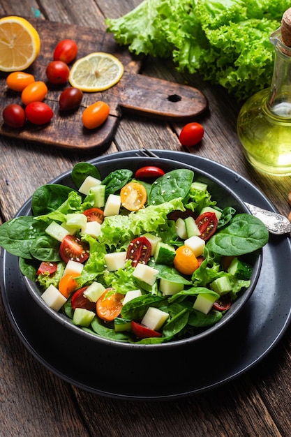 Salade van spinazie, kerstomaatjes en kaas in een bord