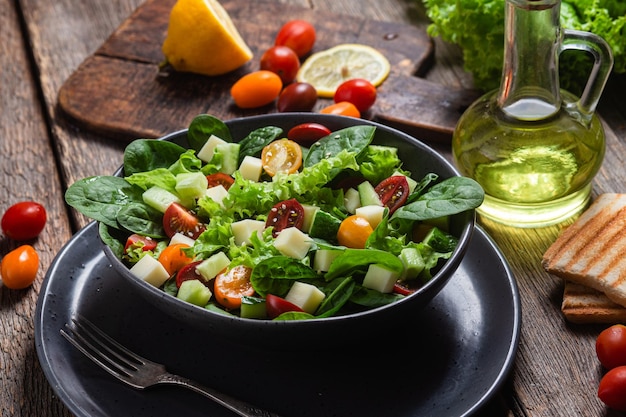 Salade van spinazie, kerstomaatjes en kaas in een bord