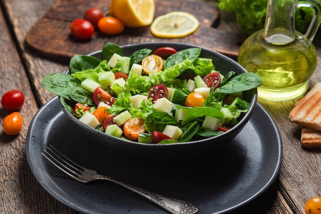 Salade van spinazie, kerstomaatjes en kaas in een bord