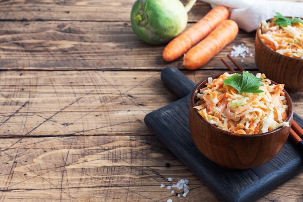 Salade van vers geraspte wortelen en groene radijs met saus