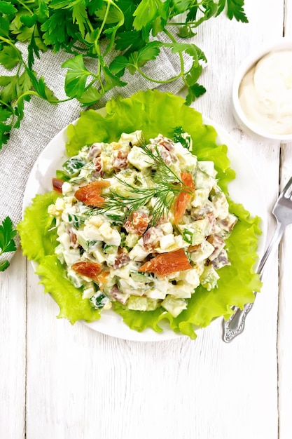 Foto salade van zalm en avocado met mayonaise op licht bord