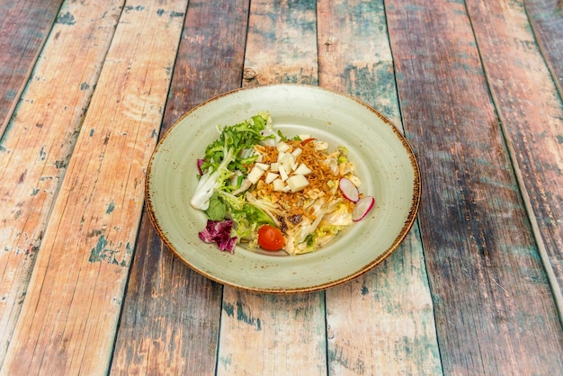 Saladebord met sla, in blokjes gesneden kaas, krokante ui, kerstomaatjes en plakjes radijs